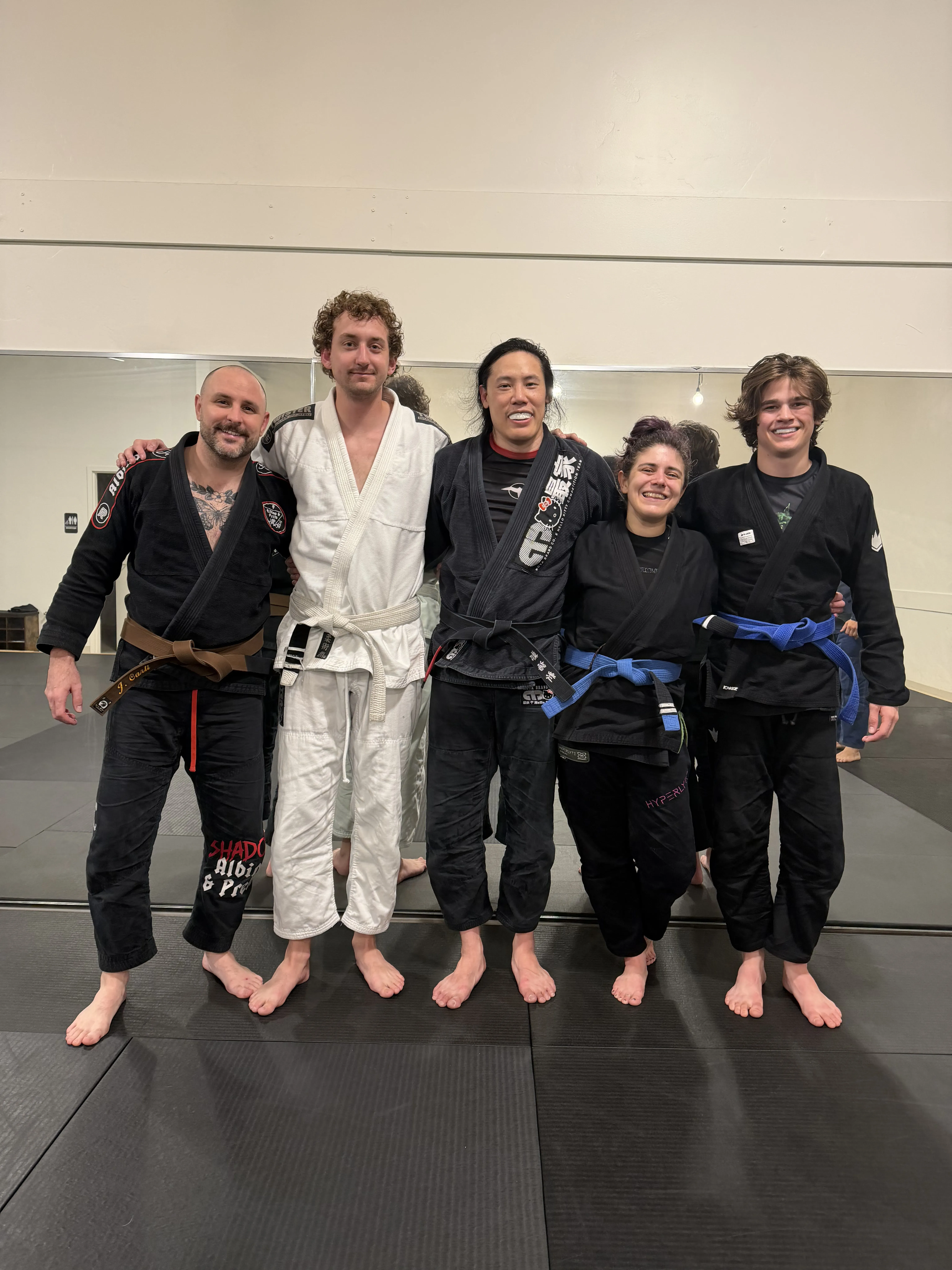 Academy crew grouped together on the mats after training.