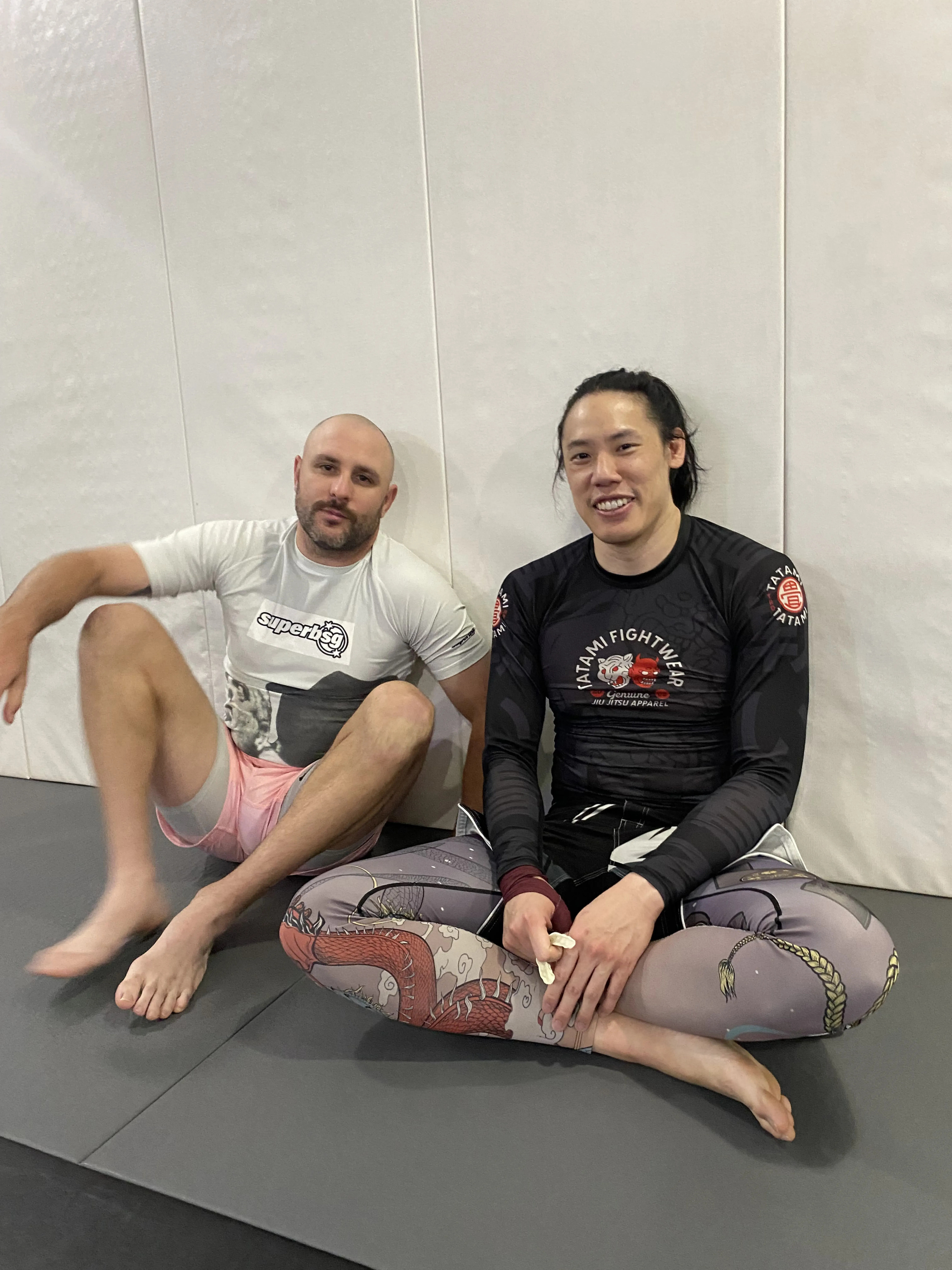 Two teammates posing together in the training room.
